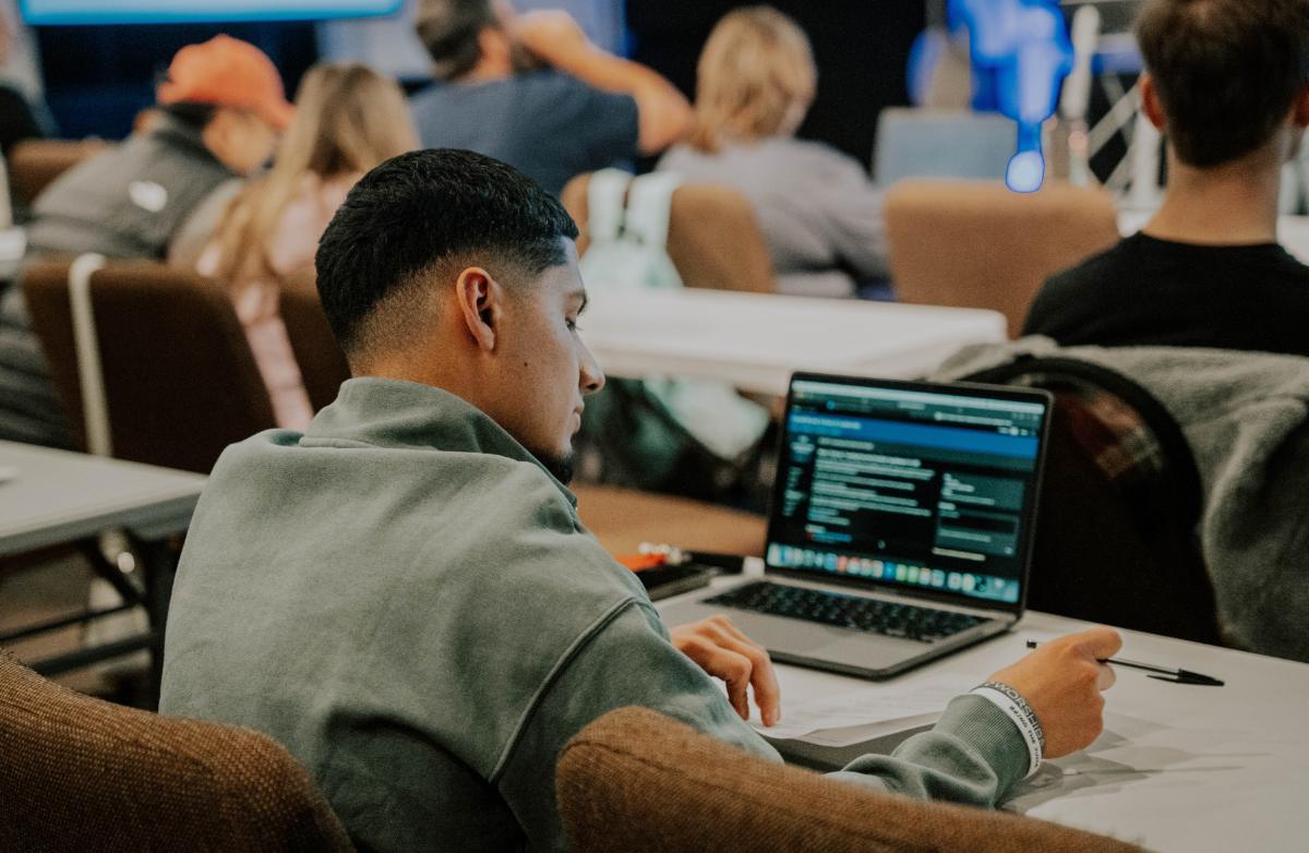 Student taking notes at a School of Leadership class